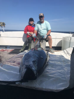 Captain and guest with tuna on deck