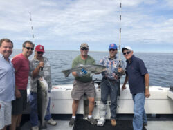 Captain and fishing party with striped bass