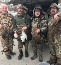 Four hunters with sea ducks