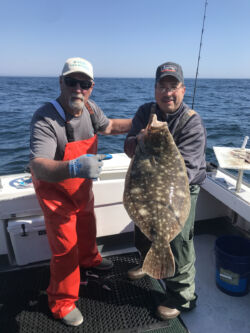 Captain Abdow with customer holding up large flounder caught on charter fishinng trip