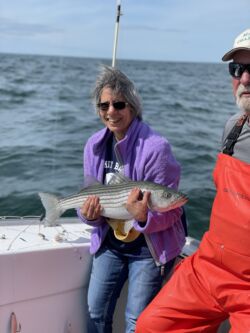 Woman holding striper caught on fishing trip